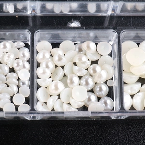 Close-up of white half-round faux pearls in organized storage case for nail art design