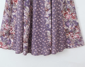 Vue détaillée du motif floral paisley violet sur un tissu fluide et léger