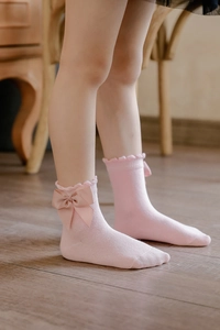 Detail of pink cotton princess socks with large bow and delicate lace trim on kids