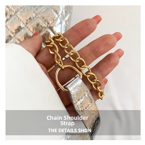 Close-up of golden multi-layer chain strap and silver quilted leather bag details