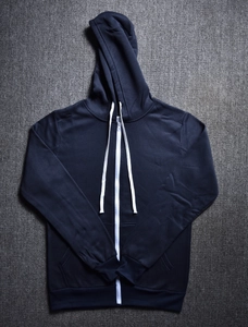 Detail of navy blue zip-up hoodie showing metal zipper, white drawstrings and ribbed cuffs