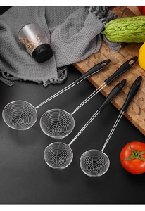 Set of four stainless steel kitchen strainers with black long handles on a rustic counter