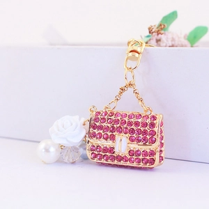 Pink rhinestone camellia flower handbag keychain with gold finish and pearl charms