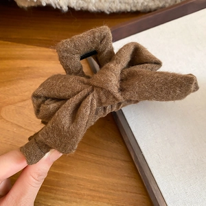 Close-up of brown plush bow hair claw clip showing soft fabric texture and sturdy design