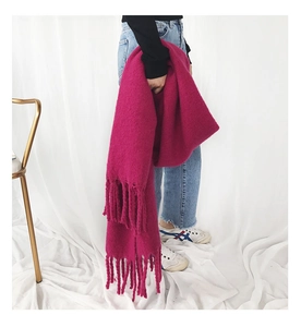 Detail view of fuchsia cashmere-like scarf with thick fringe and soft knitted texture