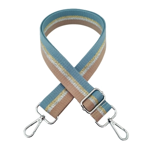Dettaglio tracolla regolabile in tessuto con fili metallici color oro e argento lucido