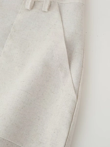 Detail showing the linen texture, side pockets, and stitching of the beige two-piece set