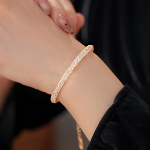 Détail du bracelet en maille dorée avec chaîne ajustable porté sur le poignet