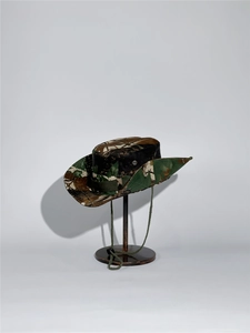 Detail of outdoor jungle camouflage bucket hat with vent holes and adjustable wind cord