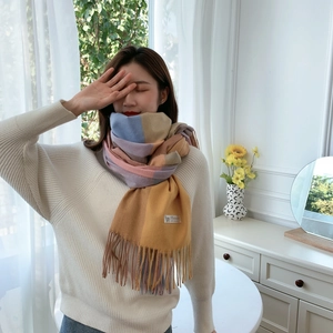 Close-up of soft cashmere scarf texture and pastel color block design with tassels