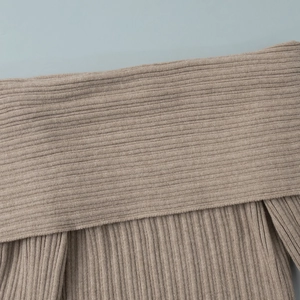 Detail of soft ribbed knit fabric texture on a brown off-the-shoulder knitted dress