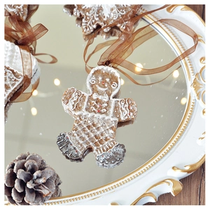 Detailed view of gingerbread man ornament with white frosting on a vintage tray