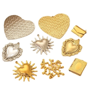 Assorted gold and silver vintage-style charms with heart and envelope designs for jewelry