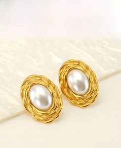 Detail of woven texture gold frame and large oval pearl on stainless steel earring