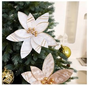 Creamy white poinsettia decoration with golden beads on a decorated Christmas tree