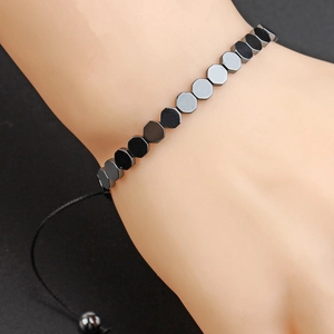 Adjustable hematite beaded bracelet with geometric hexagonal beads worn by a female model