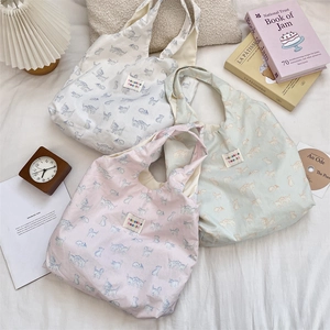 Three cat-printed canvas tote bags in white, pink, and mint green with lettered labels