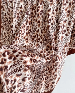 Close-up of leopard print satin fabric showing soft texture and smooth silky finish