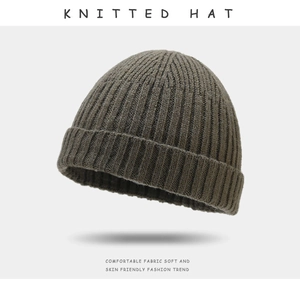 Detailed texture of olive green knitted beanie hat with soft and skin-friendly fabric