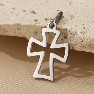 Macro shot of silver hollow-out stainless steel cross pendant on natural textured stone