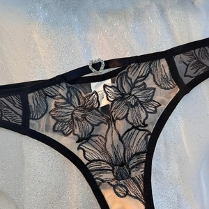 Tanga en dentelle noire avec broderie florale et boucle en strass en forme de cœur