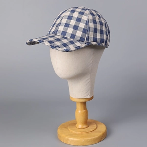 Close-up of blue gingham linen baseball cap displayed on a beige mannequin head