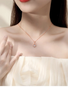 Close-up of heart swan necklace in rose gold finish on woman's collarbone