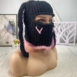 Detailed close-up of handmade knit bunny ear balaclava with pink and black contrast stitching