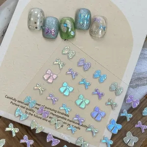 Macro shot of iridescent aurora bow nail stickers with colorful 3D ribbon designs