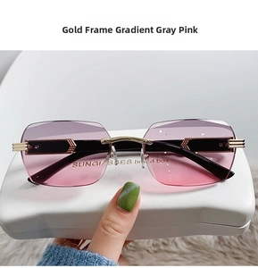 Detail of rimless gradient grey-pink sunglasses with gold arms and a white hard case