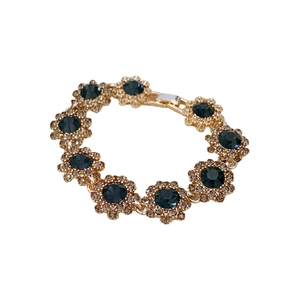 Vintage flower bracelet with blue stones and gold chain on white background