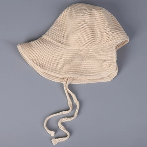 Detail of breathable cream knit bucket hat showing fine crochet texture and adjustable ties