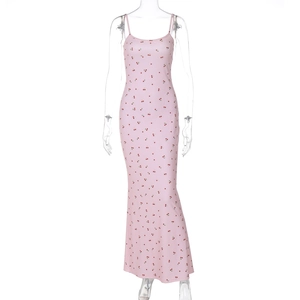 Détail d'une robe longue rose avec imprimé cerise et coupe ajustée élégante