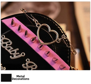 Macro detail of gothic heart handbag with punk spikes and Baby Girl hardware charm