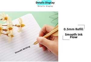 Close-up of golden arrow-shaped metal pen writing smoothly on a lined notebook