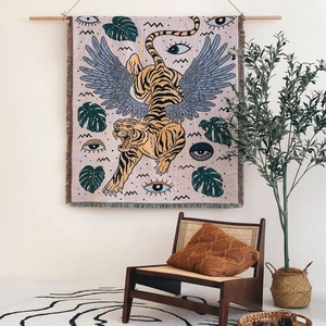 Bohemian knit blanket with flying tiger and mystical patterns hanging on a wooden rod