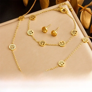 Detailed view of golden Tree of Life jewelry set including necklace, bracelet, and earrings