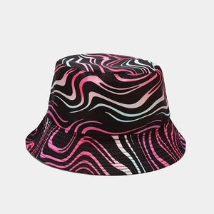 Detail of reversible bucket hat featuring pink and blue wave patterns on a black base