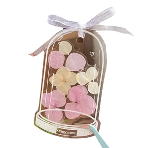 Transparent cloche-shaped bookmark kit with dried pink hydrangea and white ribbon