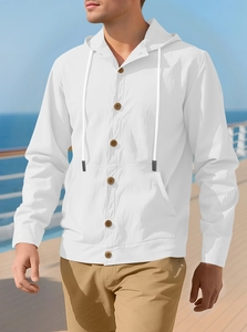 Detail of white linen hooded shirt with buttons and drawstring against sea background