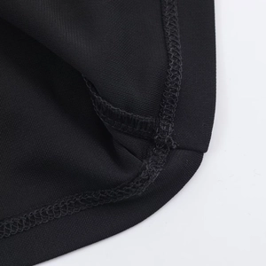 Gros plan des coutures surjetées de haute qualité sur l'ourlet d'une robe en tricot noir