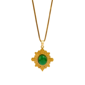Détail du pendentif soleil avec pierre verte sur une chaîne en acier inoxydable doré