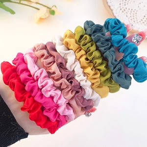 Set of eight colorful satin scrunchies in diverse vibrant shades displayed on wrist