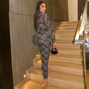 Close-up of black and white wave pattern mesh bodycon jumpsuit on female model