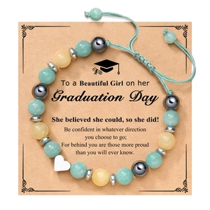 Detail of beaded friendship bracelet with heart charm on graduation greeting card