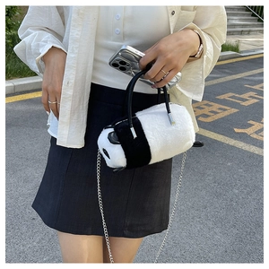 Dettaglio della borsa in peluche a forma di panda con manico in pelle e catena in metallo