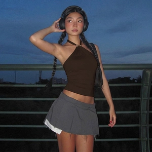 Detail of coffee brown halter backless top paired with dark grey pleated mini skirt