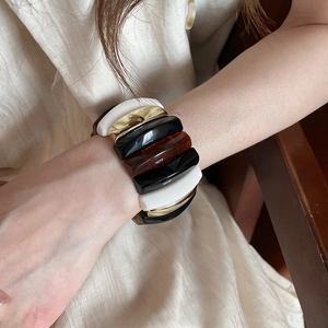 Detail of chunky acrylic resin stretch bracelet featuring marbled amber and gold accents