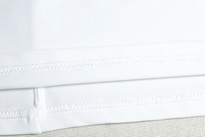 Detailed close-up of double-needle stitching and smooth knit texture on the white dress hem