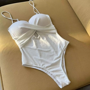White ribbed one-piece swimsuit with twist front knot design and high cut leg silhouette